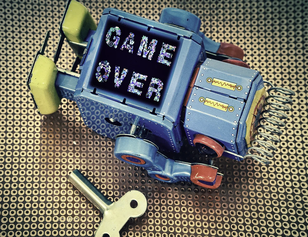 Robot that has fallen over with 'Game Over' written on its body