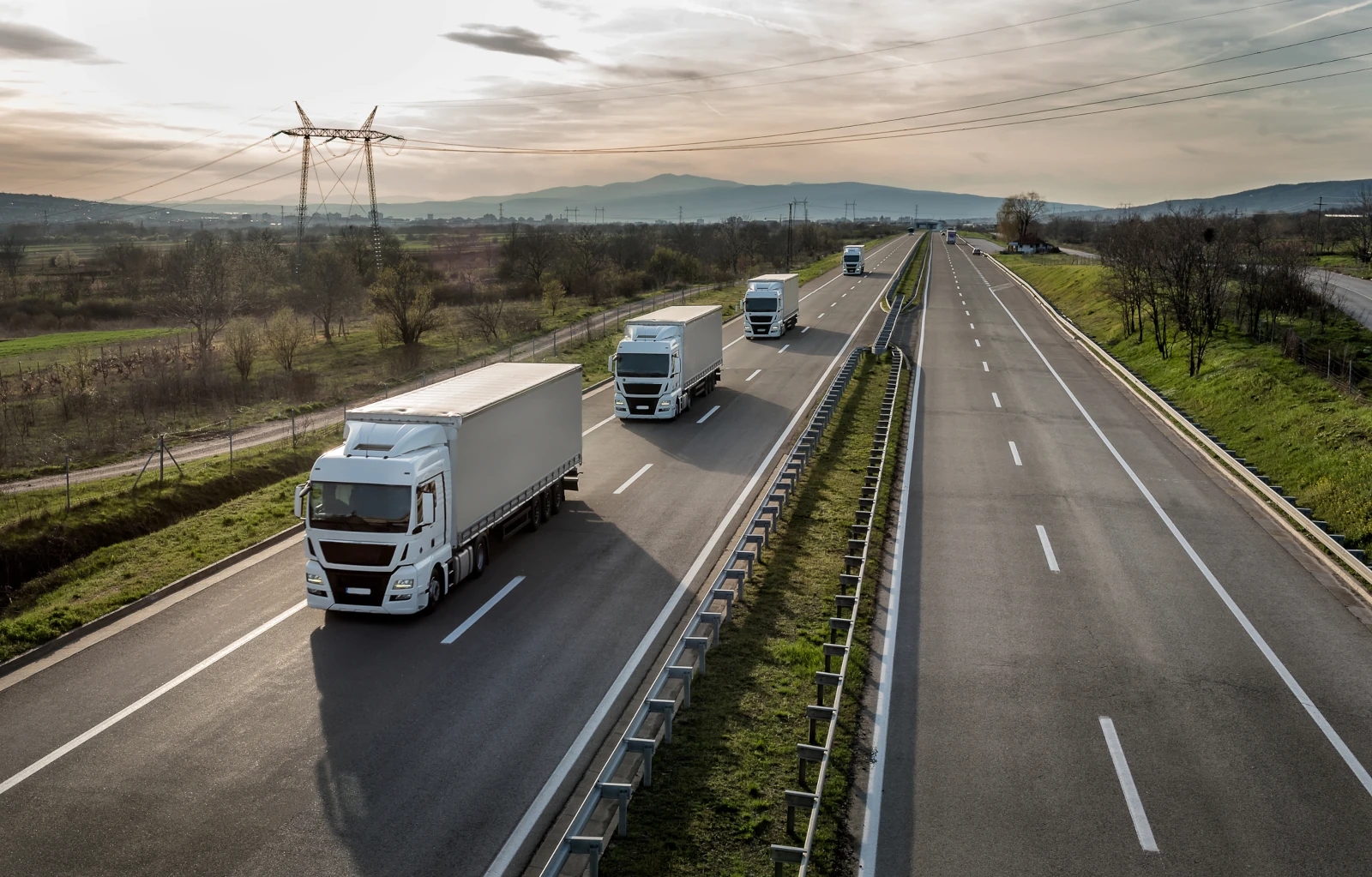 convoy of trucks in line on a country highway