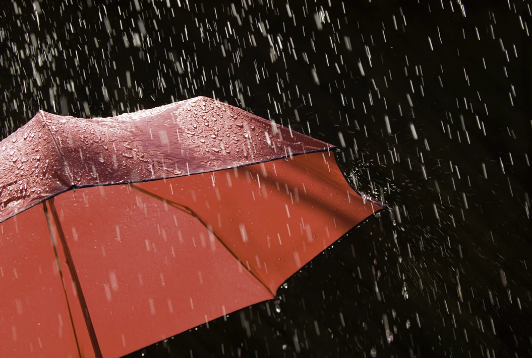 Red Umbrella and Rain Against Black Background