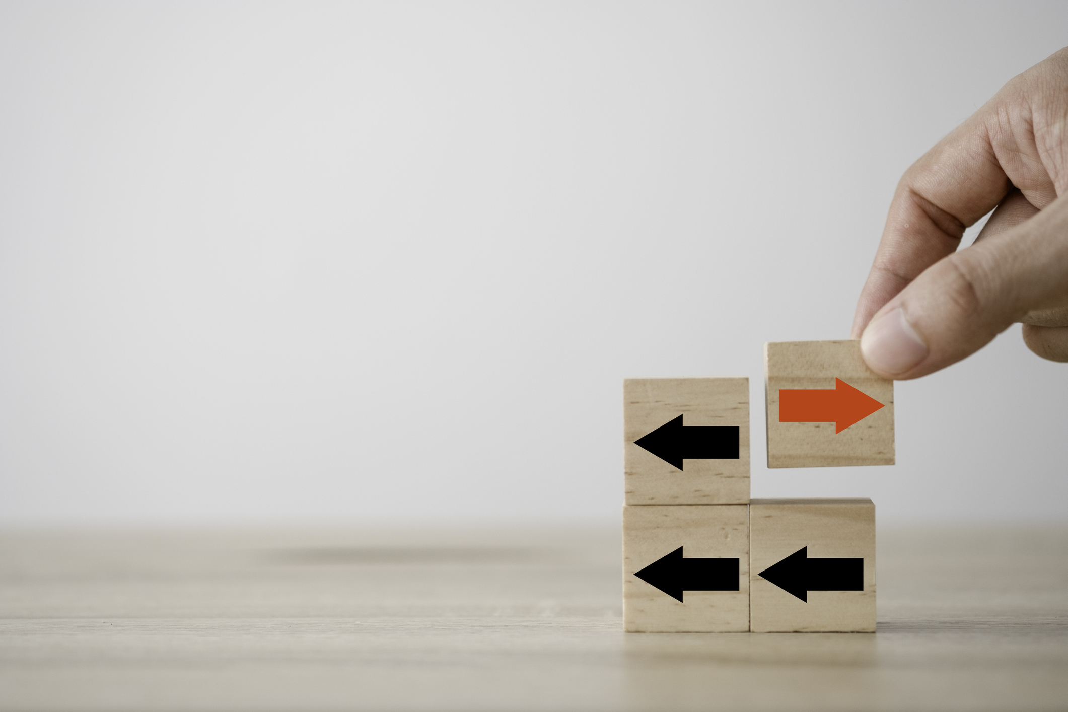red arrow on wooden cube which opposite direction with black arrow